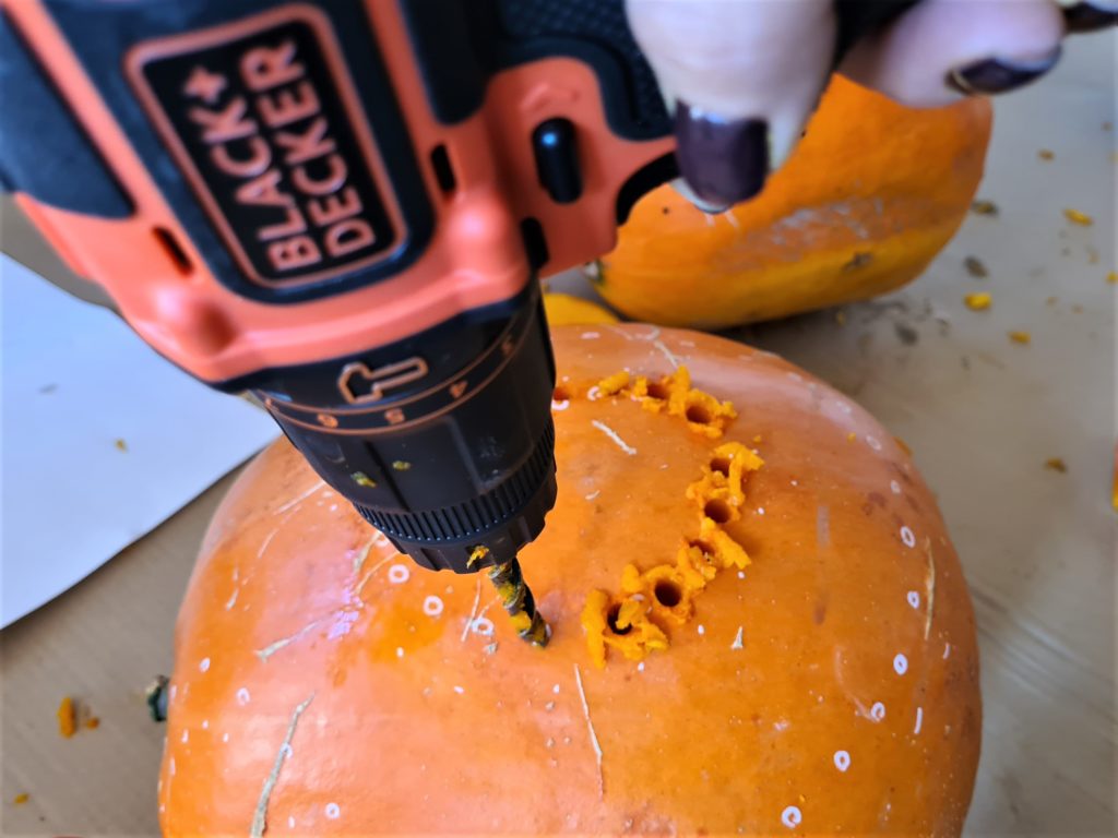 Drilling holes in the pumpkin according to the pattern